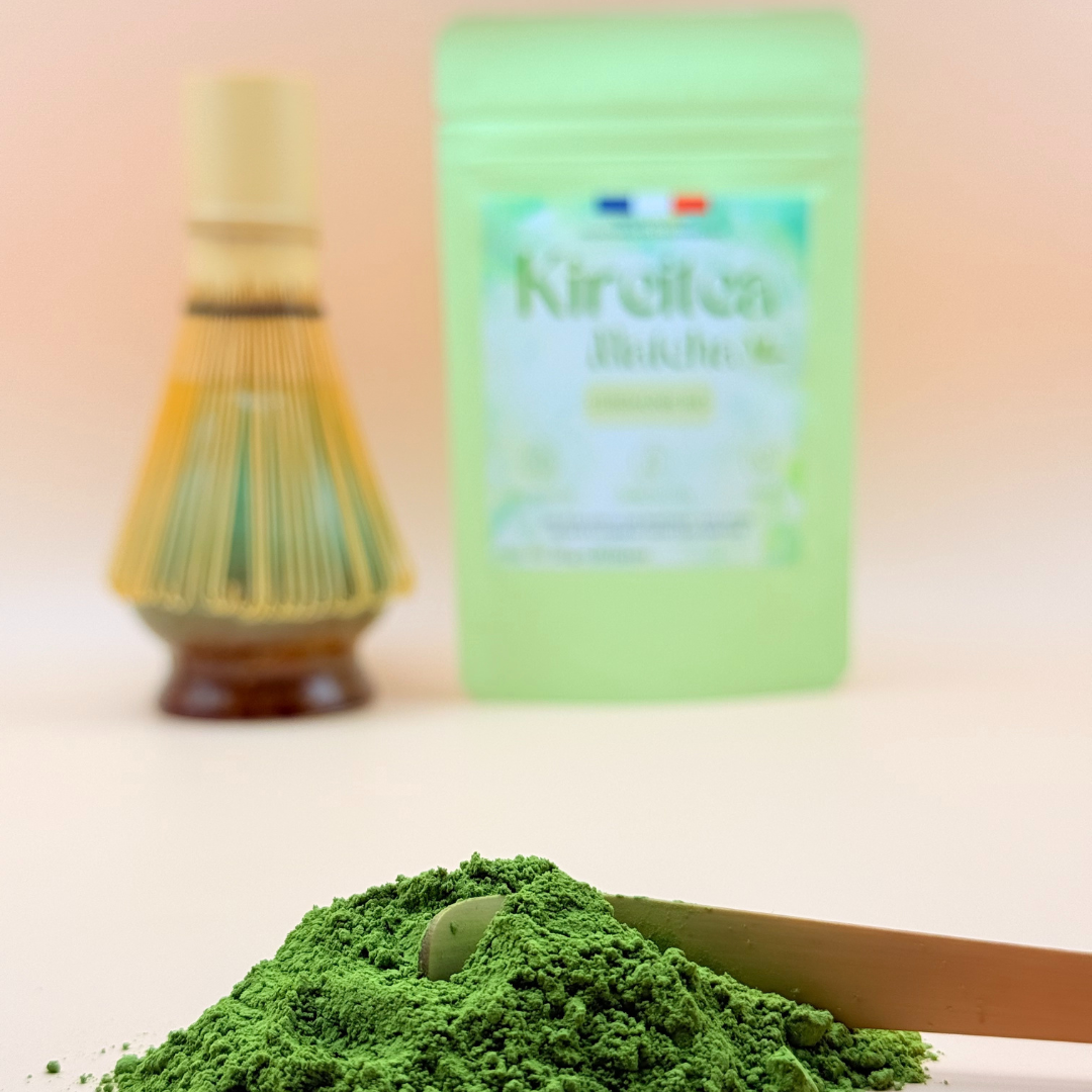 Poudre de matcha bio japonais Kireitea Matcha grade ceremonial, vert intense, avec chasen et sachet en arriere-plan, riche en antioxydants
